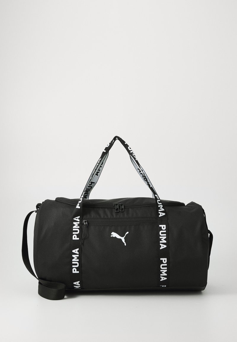 Sac de sport noir avec logo Puma blanc, en tissu durable, à doubles poignées, bandoulière réglable et accent latéral contrasté avec le nom de la marque.