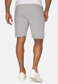 Grå, åndbare shorts lavet af blødt materiale, med lige snit og sidelommer. Sæt sammen med hvide sneakers.