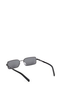 Occhiali da sole rettangolari neri con sottile montatura in metallo e lenti scure, inclinati con le aste aperte su sfondo bianco.