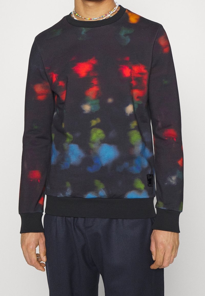 Sudadera negra con patrones abstractos multicolor en rojo, verde, azul y amarillo; mangas largas; puños y dobladillo de canalé. Textura suave.