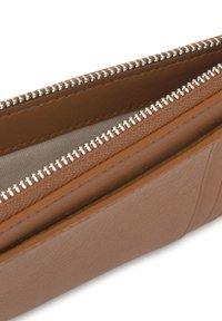 Cartera de cuero marrón con acabado texturizado, con cremalleras blancas, forro de tela claro y compartimento interno para organización.