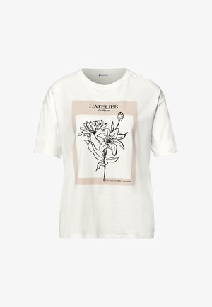 T-shirt blanc à manches courtes avec un carré beige et un dessin au trait noir de fleurs au centre, texte « L'ATELIER » au-dessus des fleurs.