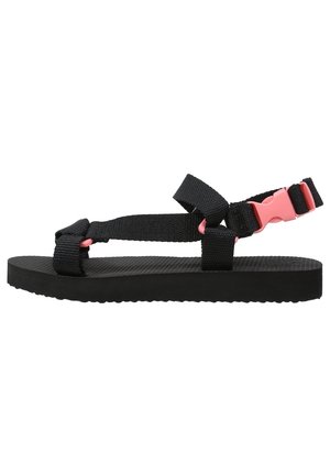 Sort sandal med justerbare nylonremme og en pink plastikspænde. Tekstureret sort gummisål, minimalistisk design. Vist fra siden.