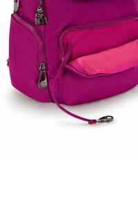 Sac à dos rose vif avec une texture brillante, doté de deux zips, dont un avec un clip, et d'une poche intérieure contrastante en rose plus clair.