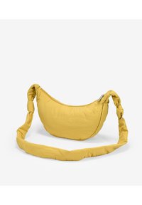 Borsa a spalla gialla in tessuto morbido con forma curvata, tracolla annodata e chiusura con zip. Texture liscia senza motivi visibili.