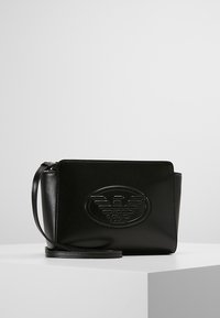 Borsa a tracolla nera in pelle con logo impresso, forma rettangolare e tracolla regolabile. Texture liscia e design minimalista.
