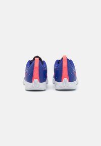 Dos zapatillas deportivas con una parte superior sintética azul, que presentan acentos en rosa y una suela blanca texturizada. En la parte trasera hay una cinta de agarre para facilitar el uso.