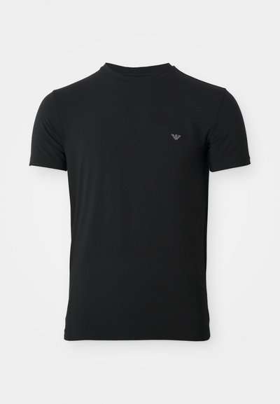 T-shirt preta de gola redonda, feita de um tecido suave, com mangas curtas e um pequeno logotipo do lado esquerdo do peito. Design de ajuste clássico.