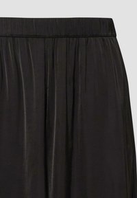 Jupe en satin noir avec une large ceinture et des plis doux créant de délicates plis verticales.