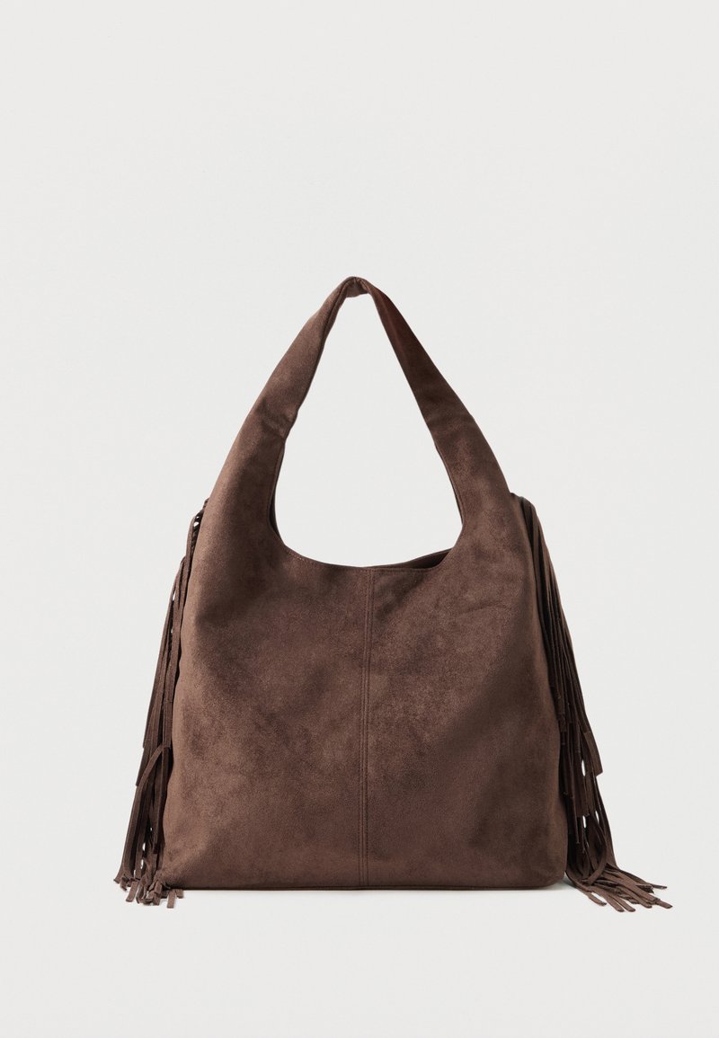 Καφέ σουέτ τσάντα ώμου με φαρδιά τιράντα και μακριές φούντες και στις δύο πλευρές, παρουσιάζεται πάνω σε απλό φωτεινό φόντο.