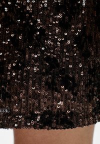 Sprakelende zwarte jurk met een sequined textuur en roségouden accenten, met een getailleerd ontwerp en een zoom van zachte, pluche details.