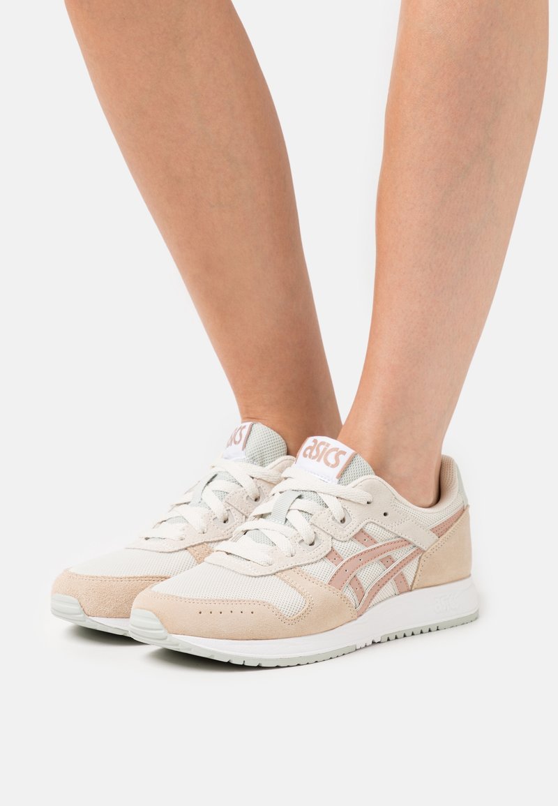 Lätta sneakers med en blandning av beige mocka och mesh, ljusrosa detaljer och en vit gummisula med rundad tådesign.