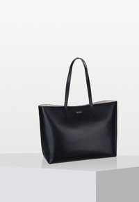 Borsa tote in pelle nera con due manici lunghi, lati piatti e un marchio sobrio al centro. Texture liscia e design minimalista.