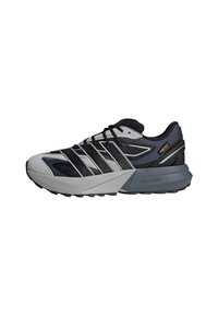 Sport Schuhe mit einem schwarzen und grauen Obermaterial, das ein strukturiertes Design aufweist, einem ausgeprägten Schnürsystem und einer gepolsterten, hellgrauen Sohle.