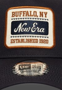 Gorra de béisbol azul marino con un parche bordado que presenta "Buffalo, NY", "New Era" y "Established 1920" en tonos crema, azul y naranja.