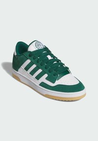 Zelene nubuk cipele i bijela koža s zelenim vezicama, s tri bijele pruge, okruglim logotipom i gumiranim potplatom.