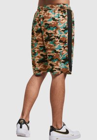 Kamuflasje shorts i brun, turkis og svart; elastisk liv; sidestrek detalj; knelengde; stoffet ser glatt og lett ut.