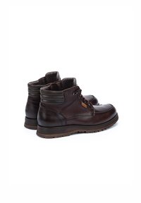 Bottines en cuir marron avec un design à lacets, accents sombres contrastants et semelle en caoutchouc texturée pour une meilleure adhérence. Comprend un col rembourré.