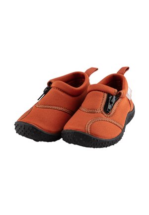 Kinderschlüpfschuh aus orangefarbenem Stoff mit schwarzen Gummisohlen. Mit elastischem Verschluss, runder Form und verstärkten Nähten.