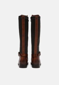 Tall boots with a black ribbed fabric body and brown leather accents. Features a side buckle and moderate heel. Rear view.