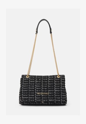 Borsa a tracolla in tweed bianco e nero con design trapuntato, catena dorata e tracolla in pelle, dotata di una placca con logo sul fronte.