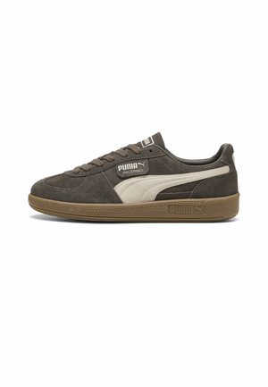 Donkergrijze suède Puma Palermo sneaker met witte logostreep en bruine rubberen zool, zijaanzicht op een witte achtergrond.
