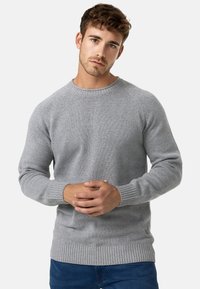 Maglione grigio a maglia con scollatura tonda, polsini e orlo a coste, caratterizzato da un motivo testurizzato. Stoffa morbida che assicura una vestibilità casual.