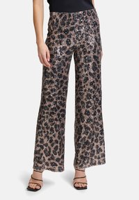 Pantalons larges à paillettes avec un motif léopard dans des tons de marron et de noir, dotés d'une taille élastique confortable et d'une texture lisse.