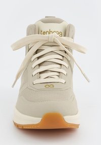 Beżowe sneakersy z siateczkową cholewką, wydłużonym językiem i okrągłymi sznurowadłami. Gruba biała podeszwa z gumowym outsole. Złote logo marki z boku.