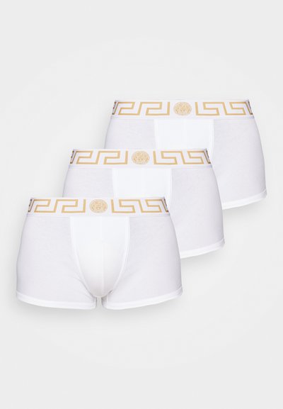 Trīs iepakojumā baltas bokseru apakšbikses ar zelta grieķu atslēgas rakstu uz elastīgā jostas, izgatavotas no mīksta kokvilnas materiāla.