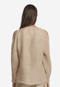 Beige Leinenoberteil mit offenem Schulterdesign, langen Ärmeln und geradem Rückennaht. Weiche Textur und lockere Passform.
