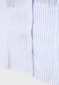 White and light blue vertically striped shirt with white buttons fastened down the front, showing detailed fabric texture and stitching.
