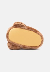 Zapatilla de felpa marrón con suela amarilla texturizada antideslizante, que presenta una forma redondeada y detalles de felpa alrededor de los bordes.