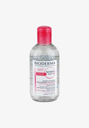 Bioderma Sensibio H2O AR, 250 ml de liquide clair dans une bouteille transparente avec un capuchon et une étiquette rose, comporte du texte sur la solution micellaire anti-rougeur.