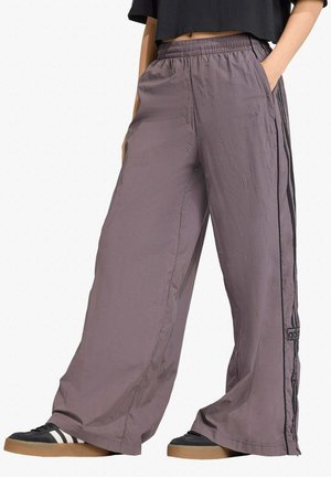 Pantaloni a gamba larga realizzati in tessuto leggero di colore viola tenue, con una striscia laterale nera e una vita elastica con tasche.