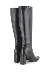 Botas de cuero negro hasta la rodilla con un diseño elegante, punta afilada y tacón cuadrado. Presentan un pequeño acento de logo en la parte superior.