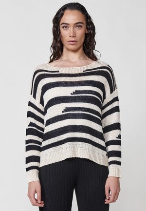 Pull en tricot rayé en crème et marine, avec un col large et une coupe décontractée. Présente des poignets côtelés et un ourlet légèrement court.