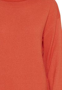 Suéter rojo de punto con un cuello redondo acanalado, que presenta una textura suave y hombros caídos. Tela ligera y ajuste cómodo.