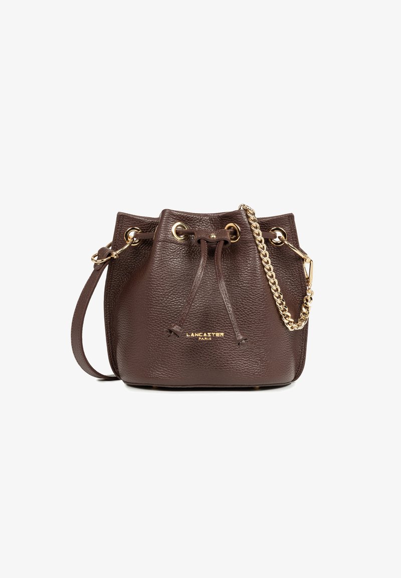 Borsa a secchiello in pelle marrone con chiusura a coulisse e tracolla in catena dorata, impressa con il logo "LANCASTER PARIS" sul fronte.
