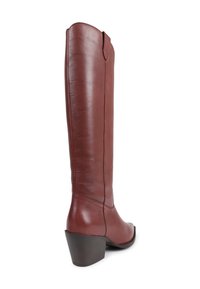 Tall brown leather boot with a stacked heel, rounded toe, and minimal stitching, shown from a rear side angle on white background.