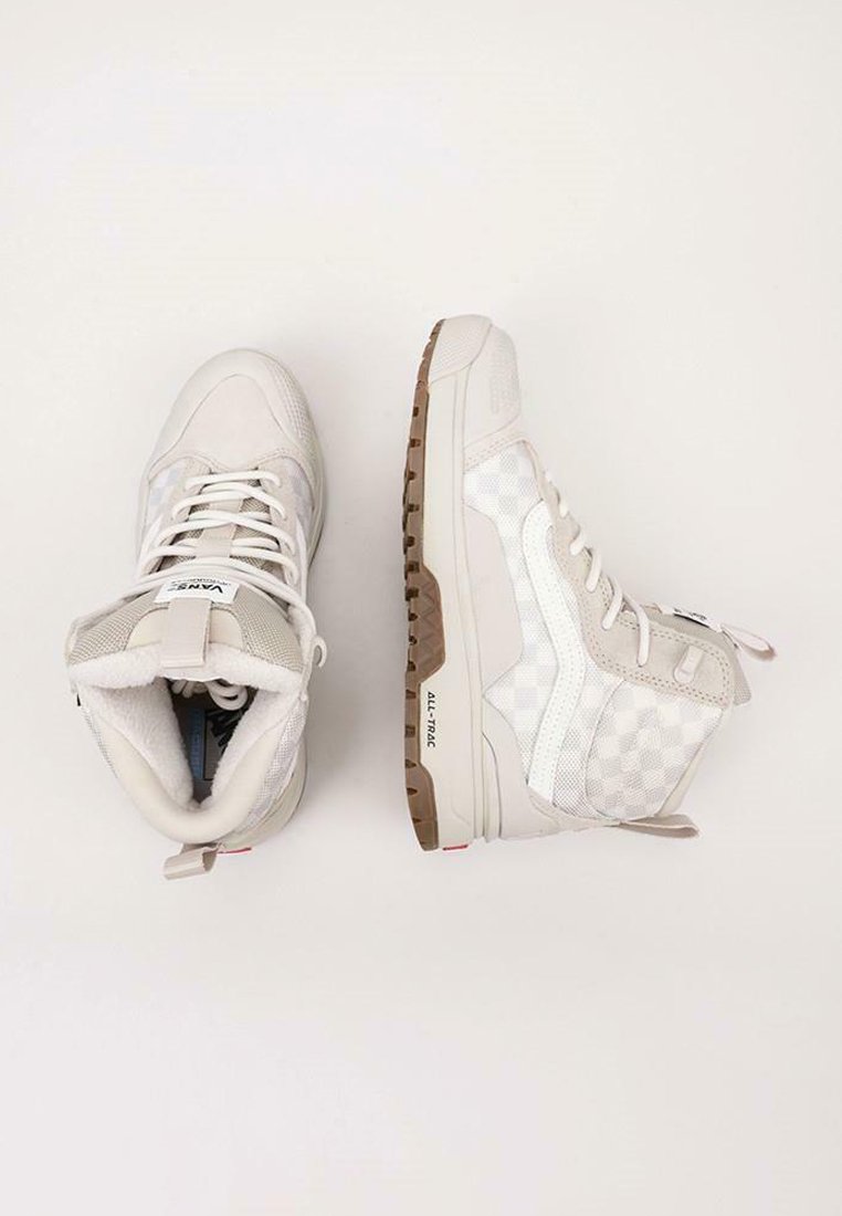 Hoge sneakers in lichtgrijs en wit. Gemaakt van suede en mesh met een geruit patroon. Voorzien van een rubberen zool en vetersluiting.