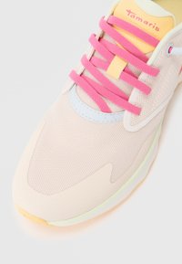 Baskets légères avec une tige en mesh rose pâle, dotées de lacets roses, d'une languette jaune et d'accents vert menthe et bleu.