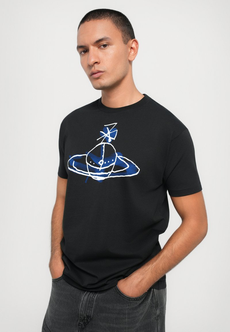 T-shirt en coton noir avec un design graphique coloré repr ésentant une planète et des anneaux en bleu et blanc, col rond et manches courtes.