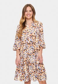 Robe à imprimé floral avec un décolleté en V, des manches cloche trois quarts et une jupe à volants. Les couleurs incluent le beige, le marron, le bleu et l'orange.