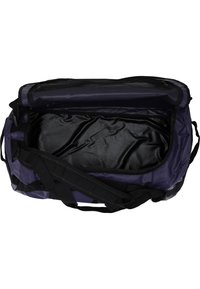 Lila duffelväska i slitstarkt tyg med svarta detaljer. Har ett rymligt svart inre, dubbla handtag och ett avtagbart axelband.