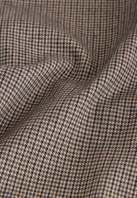 Braunes Hahnentrittmuster-Gewebe mit feiner Webstruktur. Das Muster zeigt ein Rautengitter in dunklen und hellen Brauntönen, das Tiefe und Weichheit ausstrahlt.