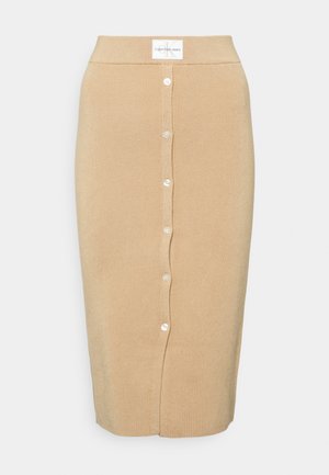 Beige resorineulekynähame, jossa nappikiinnitys edessä ja Calvin Klein Jeans -etiketti vyötäröllä.