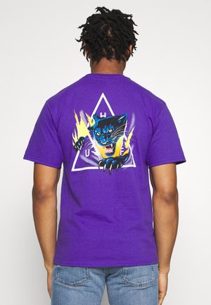 Lilla bomulds t-shirt med et grafisk motiv af en sort panter med blå detaljer, kløer strakt, omkranset af et gult flamme-design og en trekant.