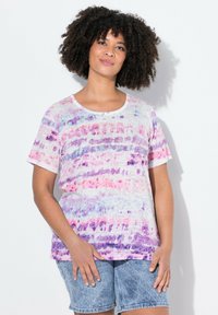 Kortærmet t-shirt med rund hals, prydet med et akvarel-lignende mønster i lilla, pink og hvid. Blødt stof, afslappet pasform, parret med denim shorts.