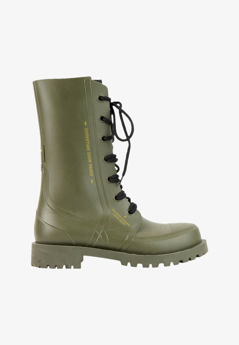 Botte haute en caoutchouc verte à lacets noirs avec texte jaune "Christian Dior Paris" sur le côté et semelle épaisse à crampons.